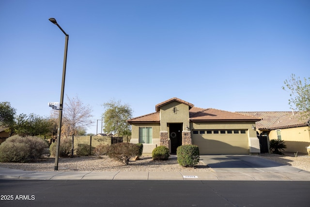 view of front facade featuring stucco siding, concrete driveway, a garage, stone siding, and a tiled roof