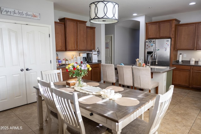 dining room with light tile patterned floors, arched walkways, and recessed lighting