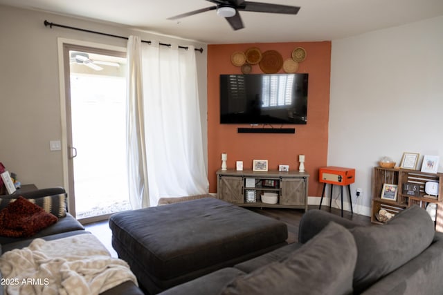 living room with ceiling fan and baseboards