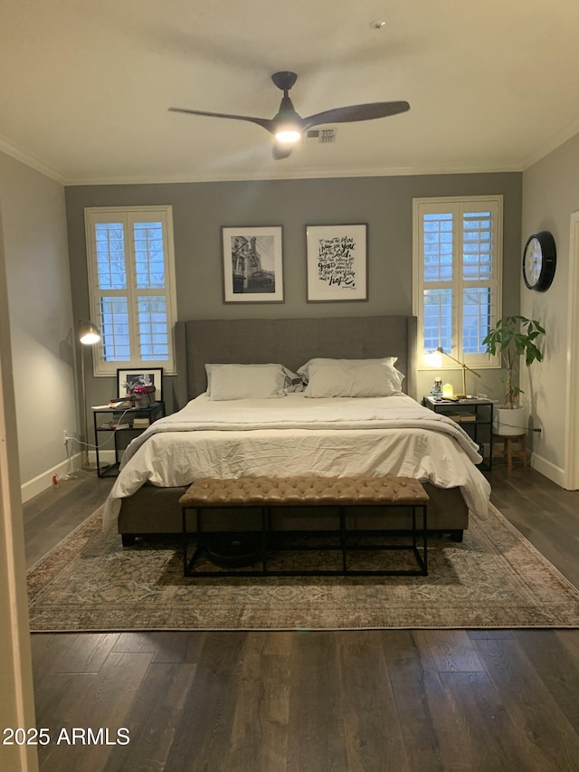 bedroom with crown molding, baseboards, and dark wood-style flooring