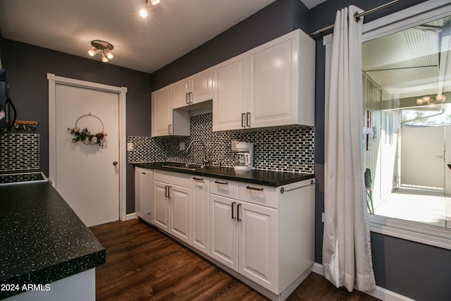 kitchen featuring decorative backsplash, white dishwasher, sink, dark hardwood / wood-style floors, and white cabinetry