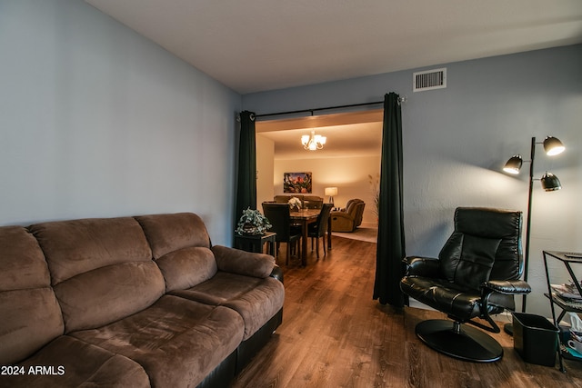 living room featuring wood-type flooring and a notable chandelier