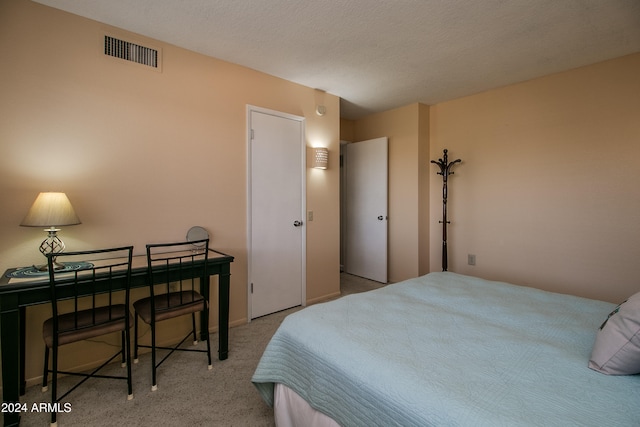 carpeted bedroom featuring a textured ceiling