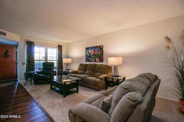 living room with dark wood-type flooring and a textured ceiling