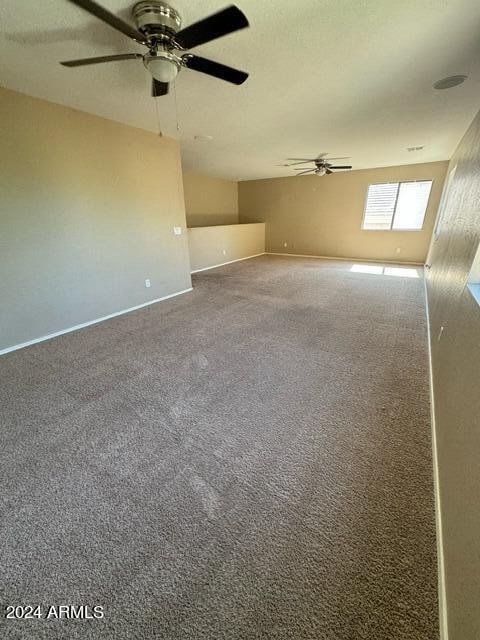 carpeted empty room featuring ceiling fan