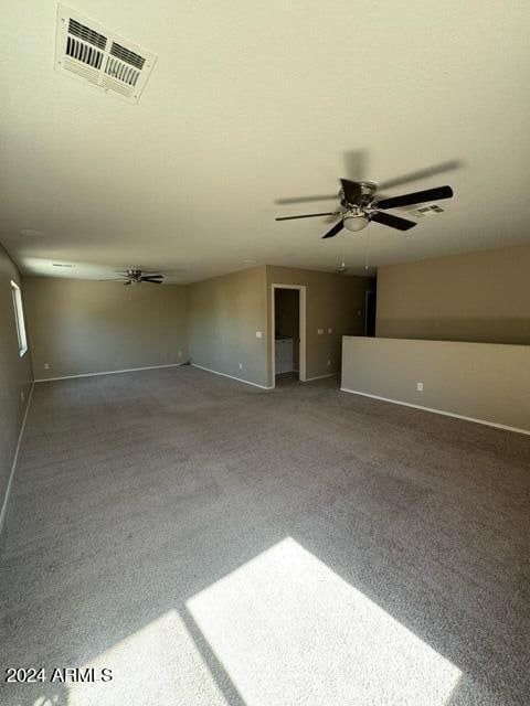 unfurnished living room with carpet and ceiling fan