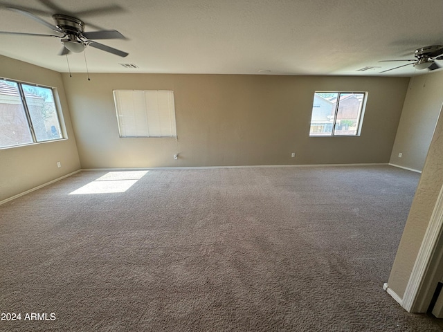 unfurnished room with a healthy amount of sunlight, carpet flooring, and ceiling fan