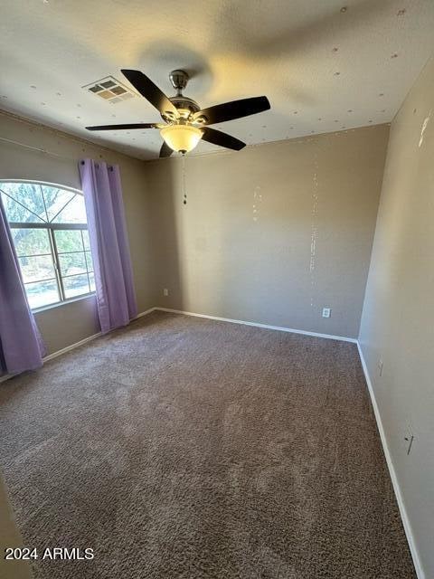 carpeted spare room with ceiling fan