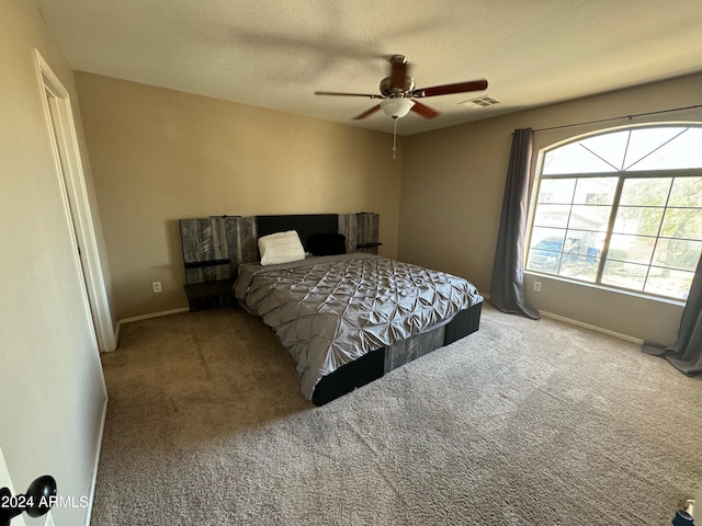 bedroom featuring ceiling fan, carpet floors, and a textured ceiling