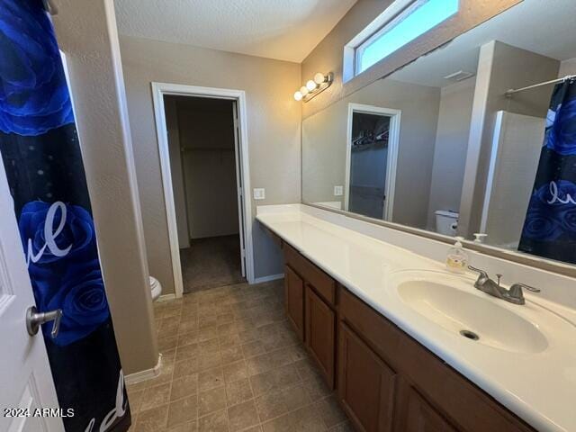 bathroom featuring a shower with curtain, vanity, and toilet