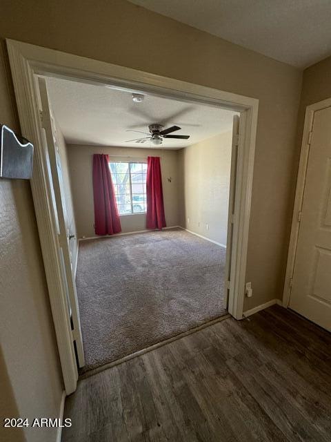 unfurnished room featuring ceiling fan and dark wood-type flooring