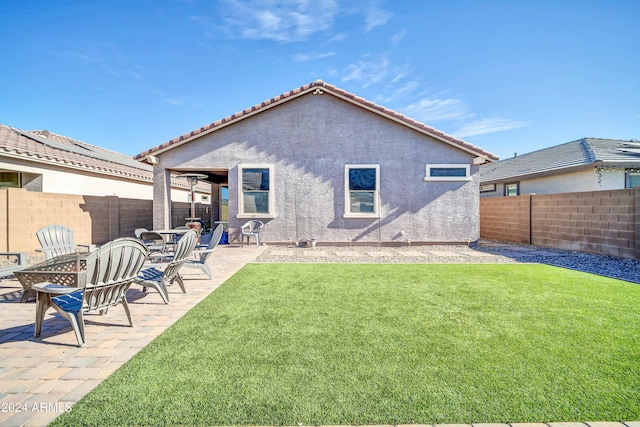 rear view of house featuring a yard and a patio