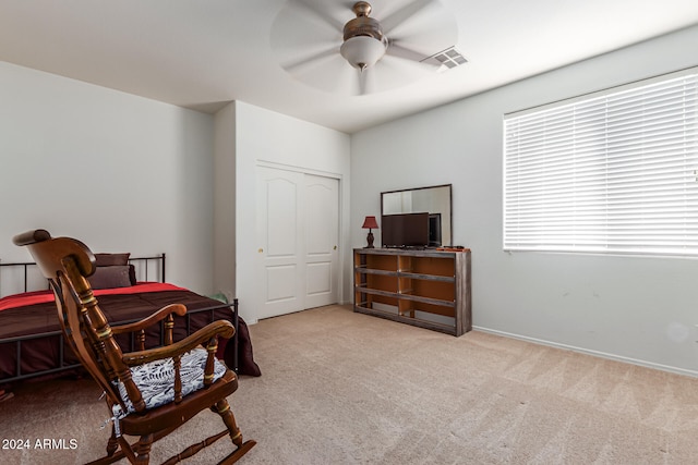 living area featuring light colored carpet and ceiling fan