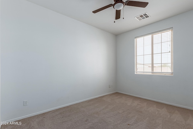 carpeted spare room with ceiling fan