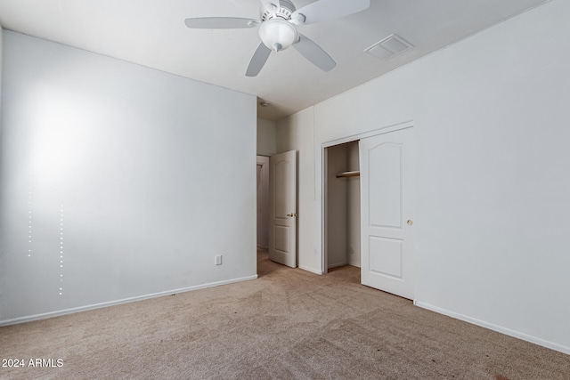 unfurnished bedroom with light colored carpet, a closet, and ceiling fan