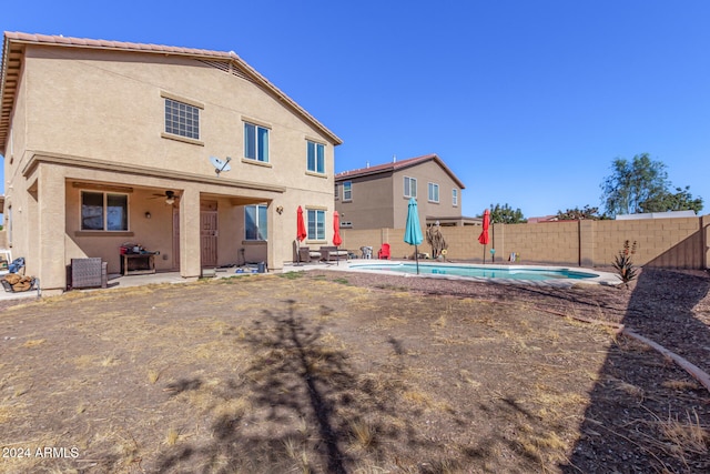 rear view of house with a patio area and a fenced in pool