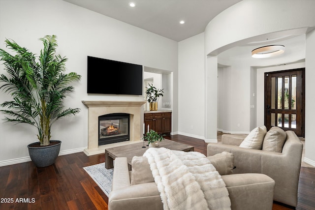 8240 E Wingspan Way, Scottsdale, AZ 85255 - living room with arched walkways, wood finished floors, a high end fireplace, baseboards, and recessed lighting