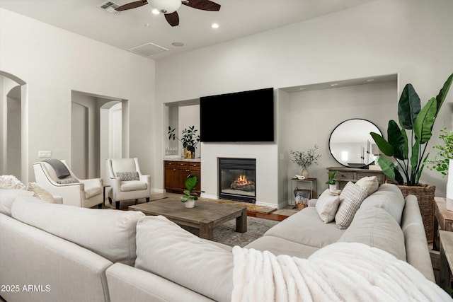8240 E Wingspan Way, Scottsdale, AZ 85255 - living room with ceiling fan, a glass covered fireplace, wood finished floors, baseboards, and recessed lighting