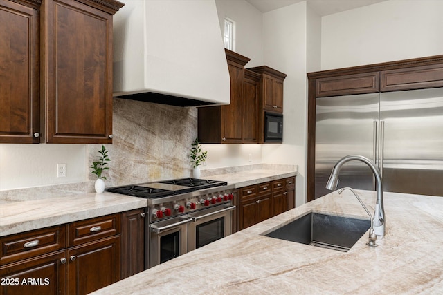 8240 E Wingspan Way, Scottsdale, AZ 85255 - kitchen with built in appliances, custom exhaust hood, dark brown cabinets, and a sink