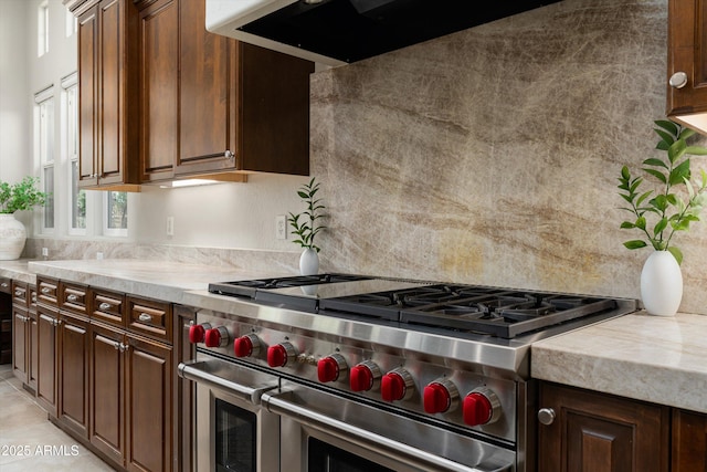 8240 E Wingspan Way, Scottsdale, AZ 85255 - kitchen featuring double oven range, light countertops, extractor fan, and tasteful backsplash