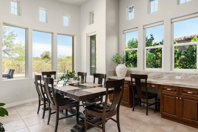 8240 E Wingspan Way, Scottsdale, AZ 85255 - dining space with a towering ceiling, light tile patterned floors, and baseboards