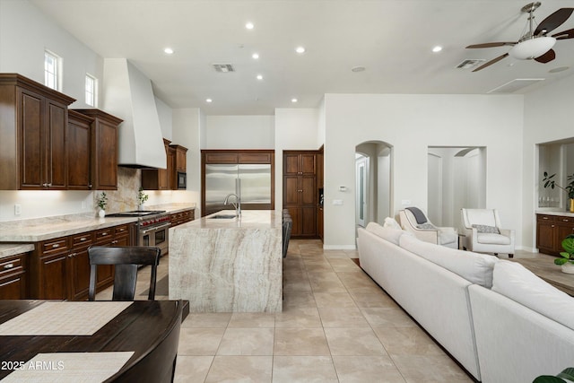 8240 E Wingspan Way, Scottsdale, AZ 85255 - kitchen with high quality appliances, open floor plan, a ceiling fan, custom exhaust hood, and light tile patterned floors