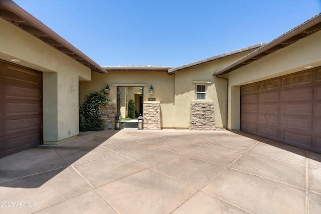 8240 E Wingspan Way, Scottsdale, AZ 85255 - view of exterior entry with stucco siding, stone siding, and driveway