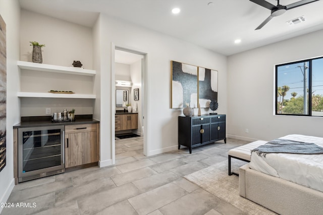 bedroom featuring wine cooler, ensuite bathroom, and bar