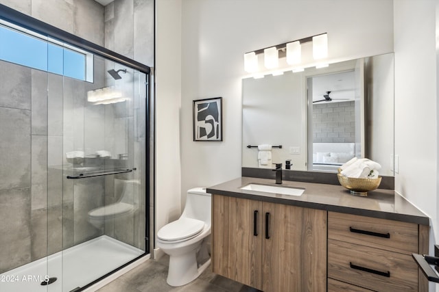 bathroom featuring vanity, toilet, and a shower with shower door