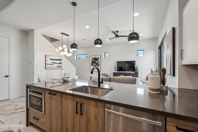 kitchen with pendant lighting, stainless steel dishwasher, sink, and white cabinets