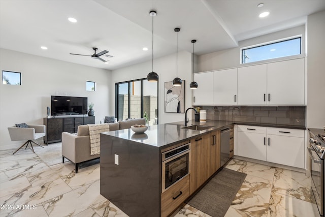 kitchen featuring sink, white cabinetry, hanging light fixtures, stainless steel appliances, and kitchen peninsula