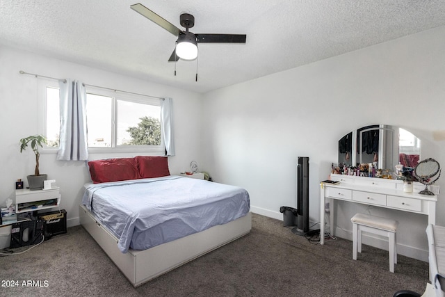 carpeted bedroom featuring ceiling fan and a textured ceiling