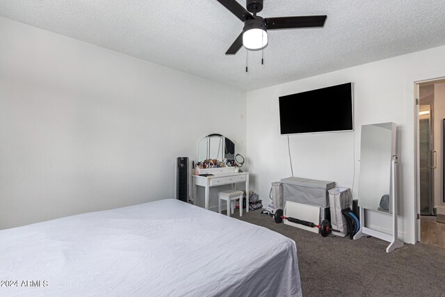 carpeted bedroom featuring ceiling fan and a textured ceiling