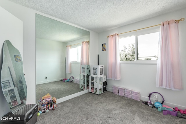 rec room featuring carpet and a textured ceiling