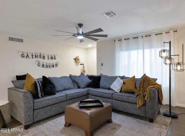 living room featuring ceiling fan with notable chandelier and hardwood / wood-style flooring