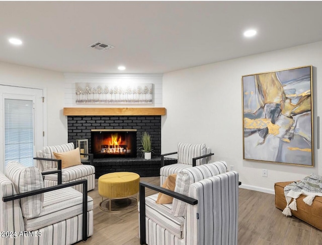 living room featuring hardwood / wood-style floors and a brick fireplace