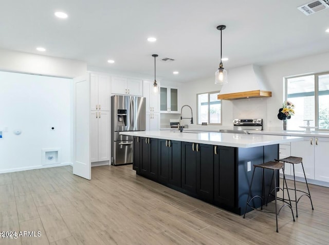 kitchen featuring premium range hood, white cabinetry, a large island, and appliances with stainless steel finishes