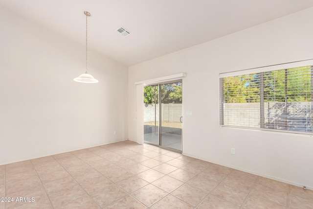 unfurnished room featuring lofted ceiling and light tile patterned flooring