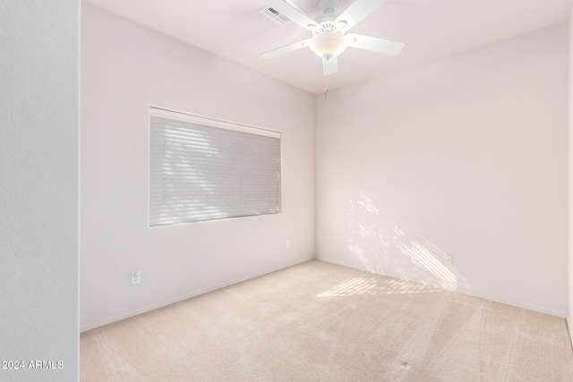 carpeted spare room featuring ceiling fan