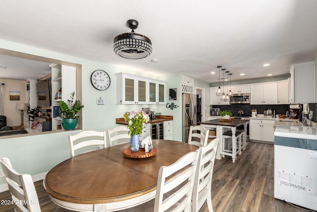 dining room with dark hardwood / wood-style floors, sink, and beverage cooler