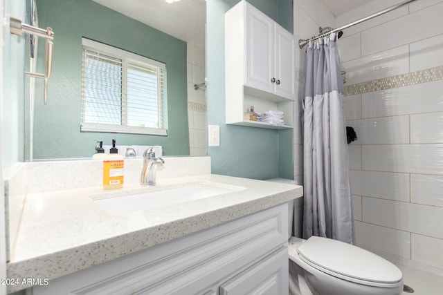 bathroom with curtained shower, vanity, and toilet