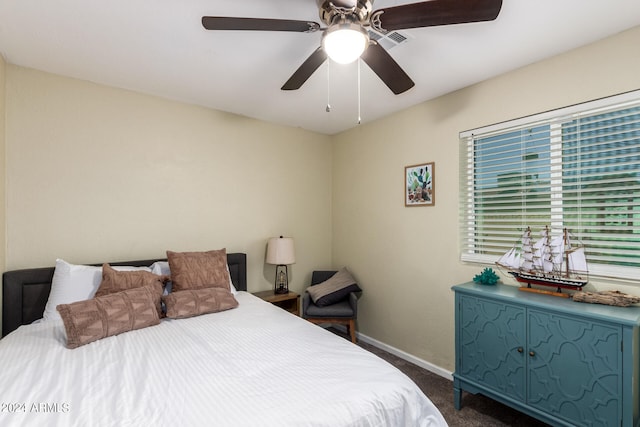 bedroom featuring ceiling fan and dark carpet