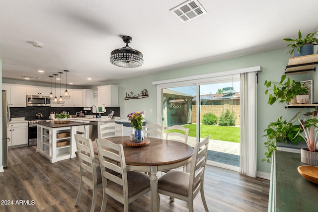 dining space featuring dark wood-type flooring and sink