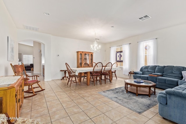 living room with light tile patterned floors and a notable chandelier