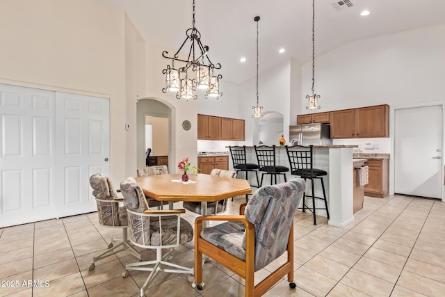 tiled dining area featuring high vaulted ceiling