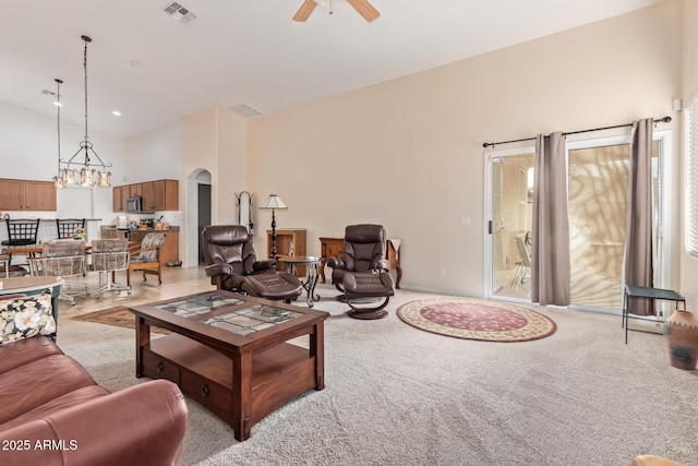 living room with high vaulted ceiling, light carpet, and ceiling fan