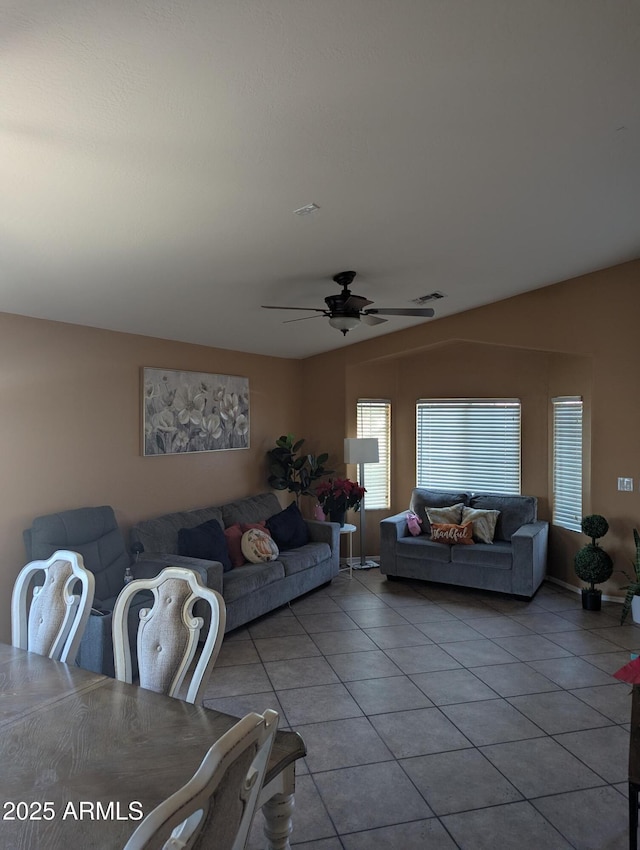 tiled living room featuring ceiling fan and lofted ceiling