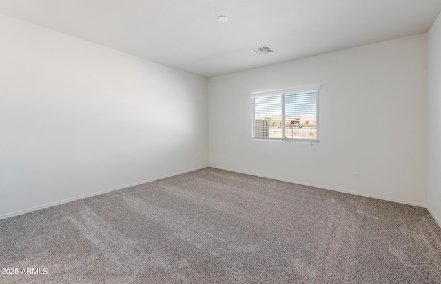 unfurnished room with carpet floors, baseboards, and visible vents