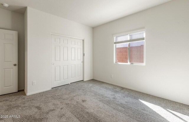 unfurnished bedroom with carpet, baseboards, and a closet