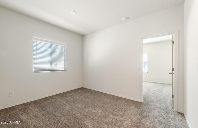 unfurnished room featuring baseboards and light colored carpet